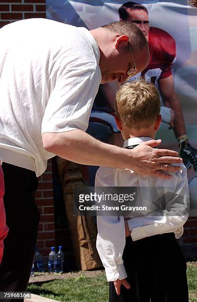 Young boy is consoled by his father as the child views a portrait of Pat Tillman at the San Jose Municipal Rose Garden May 3, 2004.