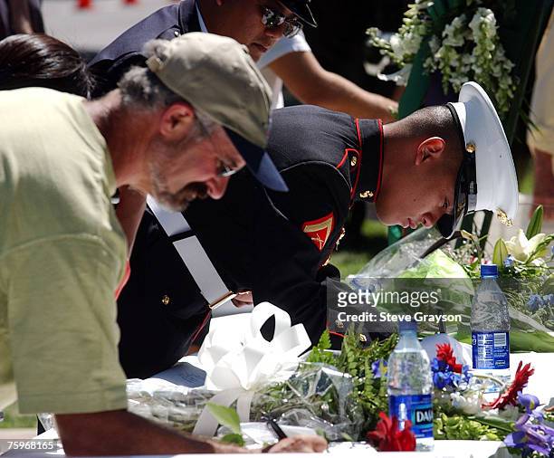 Visitors gather outside the memorial for Pat Tillman to sign a banner in his memory at the San Jose Municipal Rose Garden May 3, 2004.