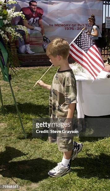 John Fender carries an American flag and wears military fatigues as he arrives at the memorial service for Pat Tillman at San Jose Municipal Rose...
