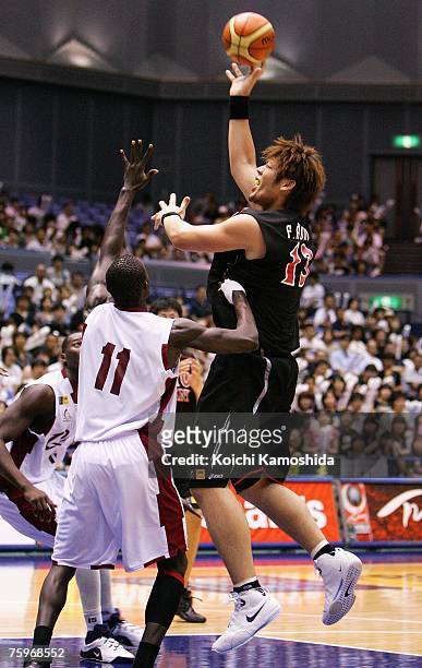 Fumihiko Aono of Japan shoots against Erfan Aseed of Qatar during the 2007 FIBA Asia Championship game at Asty Tokushima on August 05, 2007 in...