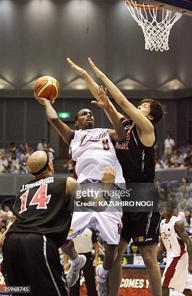 Qatar's Abdi Khalid tries to shoot the ball over Japanese players J.R. Sakuragi and Joji Takeuchi during their 7-8 classification match at the Asian...