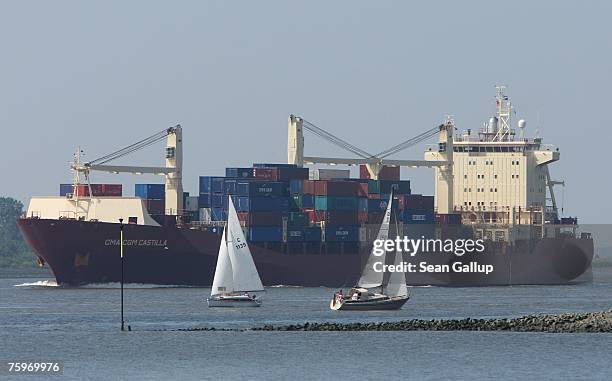 Container ship passes sailboats on the Elbe River on its way to Hamburg August 4, 2007 at Wedel, Germany. Northern Germany, with its busy ports of...