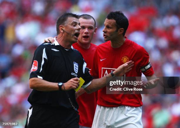 Ryan Giggs and Wayne Rooney of Manchester United talk to referee Mark Halsey during the FA Community Shield match between Chelsea and Manchester...