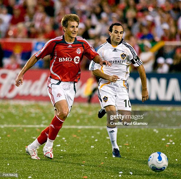 Toronto FC midfielder Chris Pozniak chases the ball with L.A. Galaxy forward Landon Donovan in pursuit at BMO Field in Toronto, Ontario, Canada on...