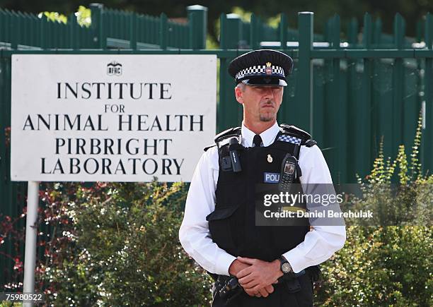 Police officer stands near the sign outside the Institute for Animal Health Pirbright Laboratory on August 6, 2007 in Pirbright, England. The...