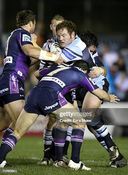 Craig Stapleton of the Sharks is tackled by the Storm during the round 21 NRL match between the Cronulla-Sutherland Sharks and the Melbourne Storm at...