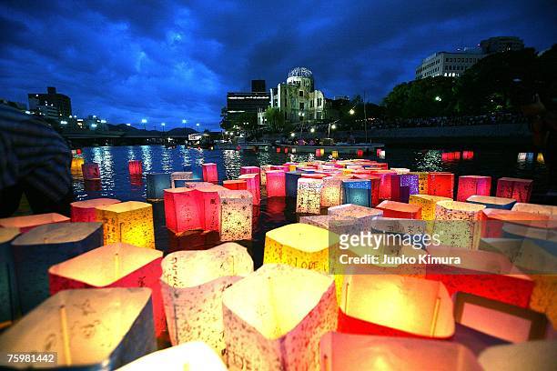 Candles and paper lanterns float on the Motoyasu River in front of the Atomic Bomb Dome at the Peace Memorial Park, in memory of the victims of the...