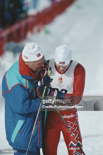 Norwegian cross-country skier Bjorn Daehlie pictured receiving assistance from a Norwegian team official after crossing the finish line in second...