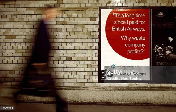 Commuter passes a poster for Go Airlines April 11, 2002 at South Kensington Underground Station in London. Go, a no-frills carrier, plans for an IPO...