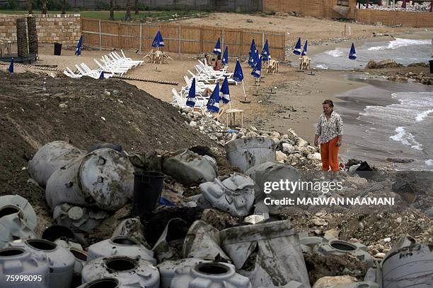 Fifi Kallab , an official from the non-governmental organisation Byblos Ecologia, walks along a beach as Lebanese sunbathe near scores of plastic...