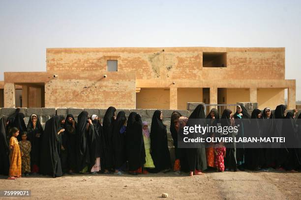 Iraqi women and children queue to receive humanitarian aid from the Iraqi Ministry of Trade in Mufrek, western Baquba, 60 kms north of Baghdad, 05...