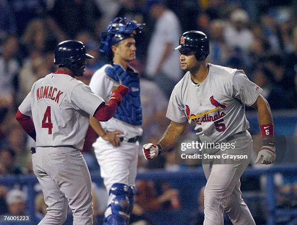Albert Puljos of the St. Louis Cardinals is greeted by Tony Womack after hitting a fourth inning home run off Wilson Alverez of the Los Angeles...