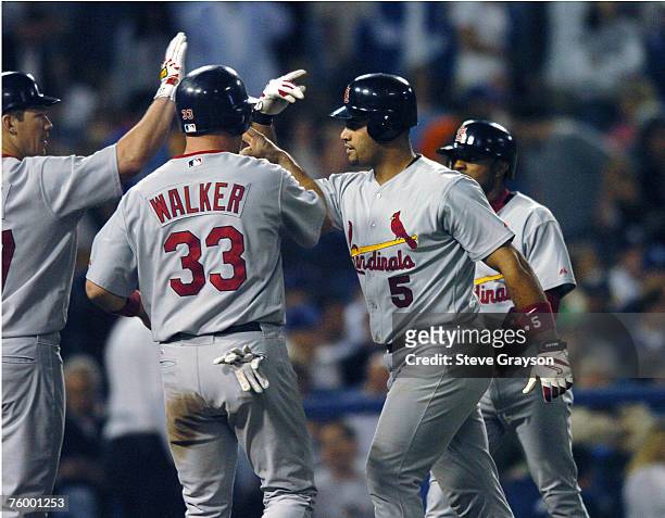 Albert Puljos of the St. Louis Cardinals is greeted at home plate after hitting a fourth inning home run off Wilson Alverez of the Los Angeles...