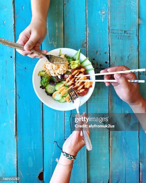 three people sharing a poke bowl - pokes stock pictures, royalty-free photos & images