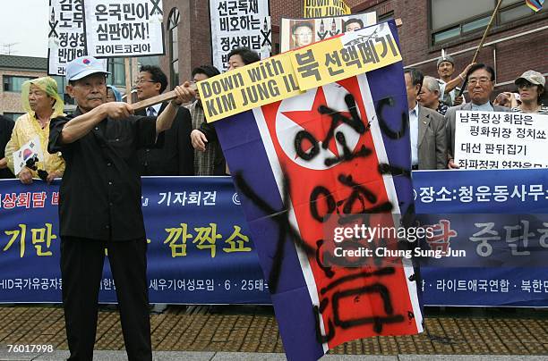 South Korean protester holds a North Korea's national flag with the writing "Stop The Summit" during a rally against the upcoming meeting of South...