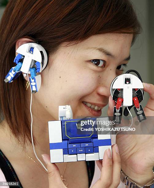 Japan's toy giant Tomy ermployee Chie Yamada displays a MP3 player "Transformer Music Label Soundwave" and hearphones based on characters of the...