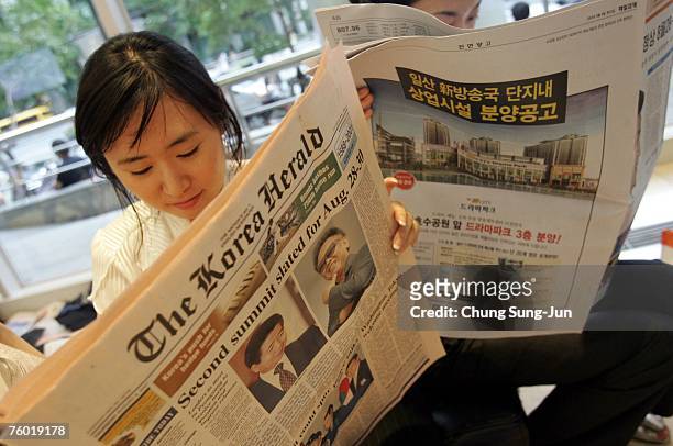 South Koreans read newspapers reporting on the upcoming August 28-30 summit in the North Korean capital Pyongyang between their president Roh...