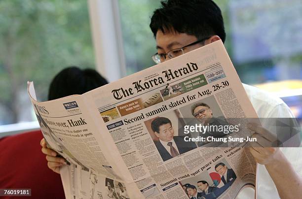South Koreans read newspapers reporting on the upcoming August 28-30 summit in the North Korean capital Pyongyang between their president Roh...
