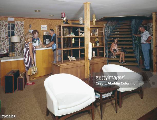 Couple fills out paperwork for the female clerk at the front desk of the Plantation Motel while a young girl with a pair of dogs sits on a staircase...