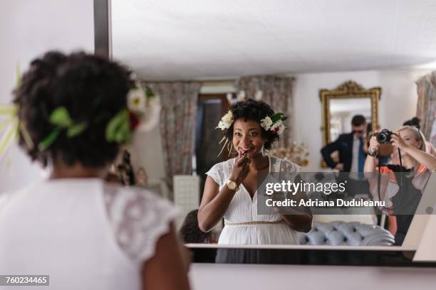 Reflection Of Bride Applying Lipstick While Standing In Front Of Mirror