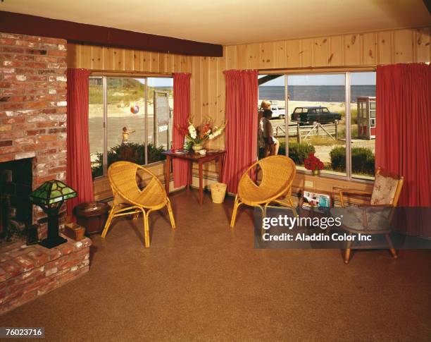 View of the lobby of the Chatham Tides hotel, South Chatham, Cape Cod, Massachusetts, 1960s. Outside the window several children play, and the ocean...