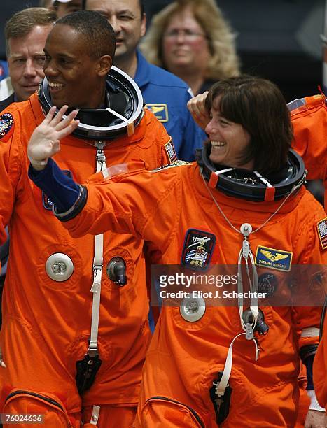 Space Shuttle Endeavour astronauts, mission specialists and former teacher Barbara R. Morgan and Alvin Drew Jr. Wave as they walk out of the...