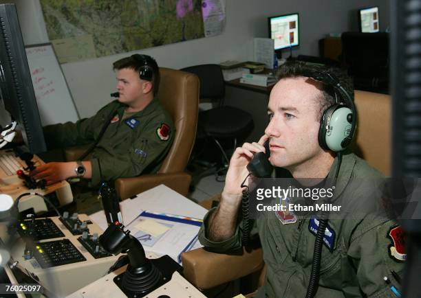 United States Air Force Maj. Casey Tidgewell and Senior Airman William Swain operate an MQ-9 Reaper from a ground control station August 8, 2007 at...