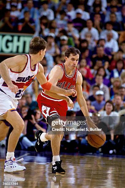 John Paxson of the Chicago Bulls looks to drive to the basket against Danny Ainge of the Phoenix Suns in Game Six of the 1993 NBA Finals on June 20,...
