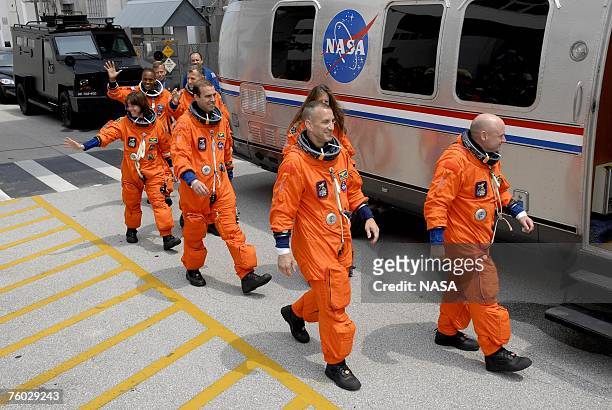 In this handout photo provided by the National Aeronautics and Space Administration, the STS-118 crew waves to spectators as they head for the...
