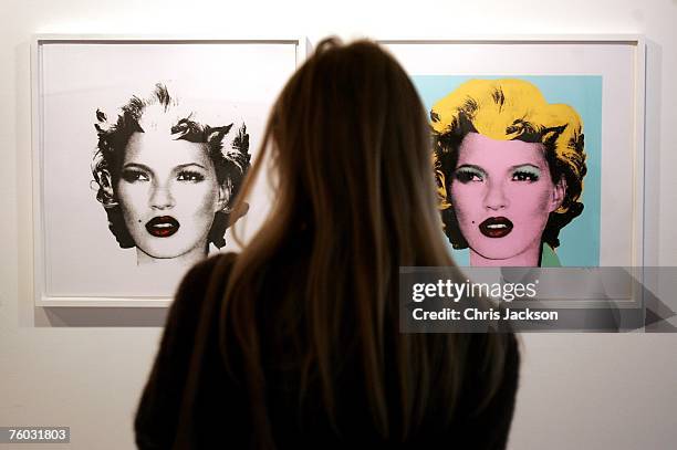 Woman looks at two screen prints of Kate Moss done in the style of Warhol's iconic Marilyn Monroe portraits by Banksy at the Warhol vs Banksy...