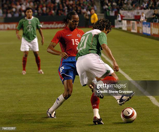 Junior Diaz of Costa Rica tries to cut off the field angle of Hector Altamirano of Mexico.