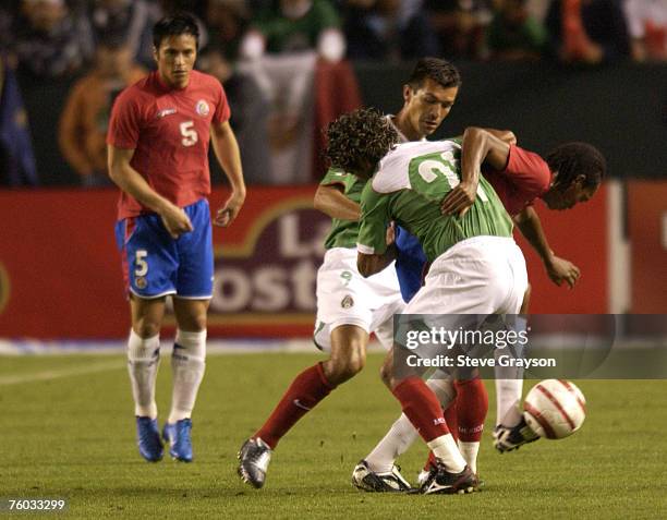 Junior Diaz of Costa Rica tries to control the ball despite pressure from a duo of defenders.