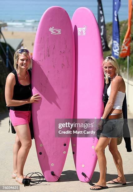 Two female surfers pose with their pink surfboards at Watergate Bay close to the site of the Ripcurl Boardmasters at Fistral Beach on August 9 2007...