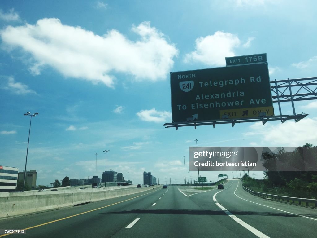 Road Sign Against Cloudy Sky