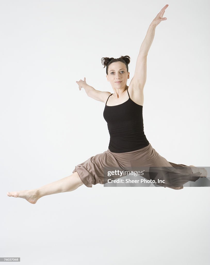 Ballet dancer jumping with arms outstretched, portrait