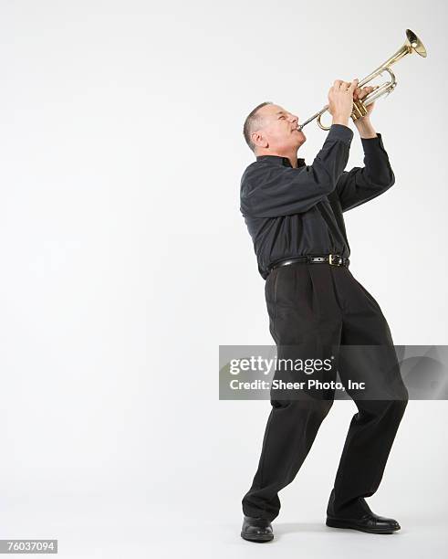 man playing trumpet, against white background - wind instrument stock pictures, royalty-free photos & images