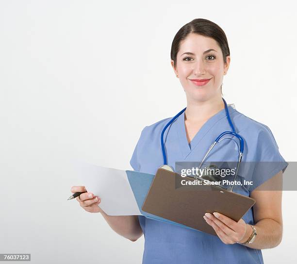 female nurse checking records, portrait - nurse and portrait and white background and smiling and female and looking at camera stock pictures, royalty-free photos & images