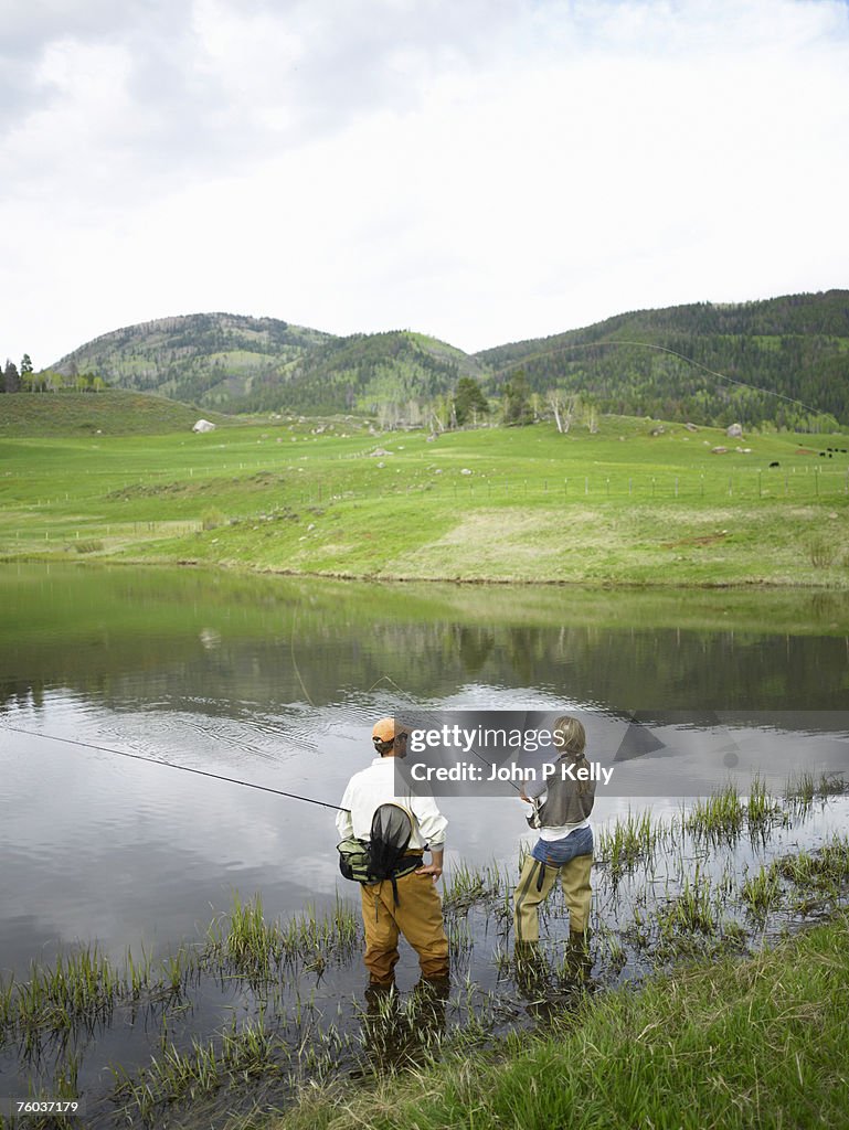 Man and woman fly fishing in lake
