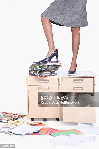 young business woman standing on filling cabinet on stack of folders, low section - single drawer filing cabinet stock pictures, royalty-free photos & images