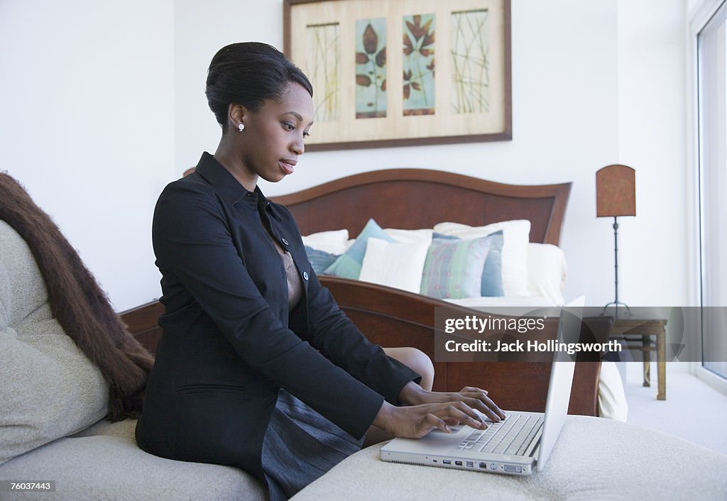 Business woman on laptop in hotel room, side view