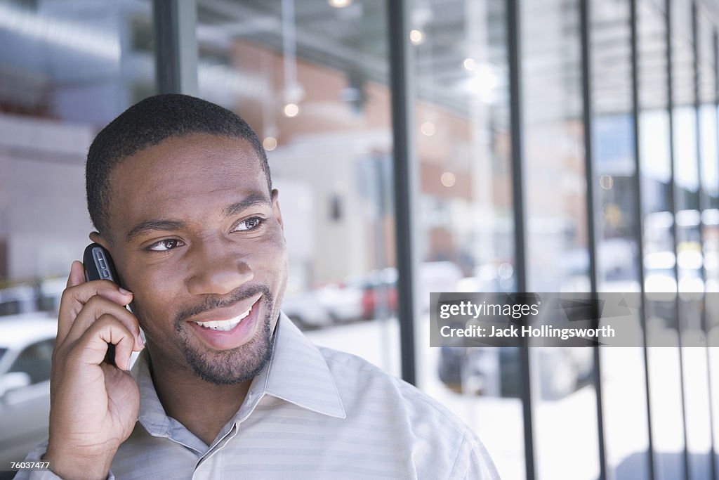 Man using mobile phone outdoors, head and shoulders