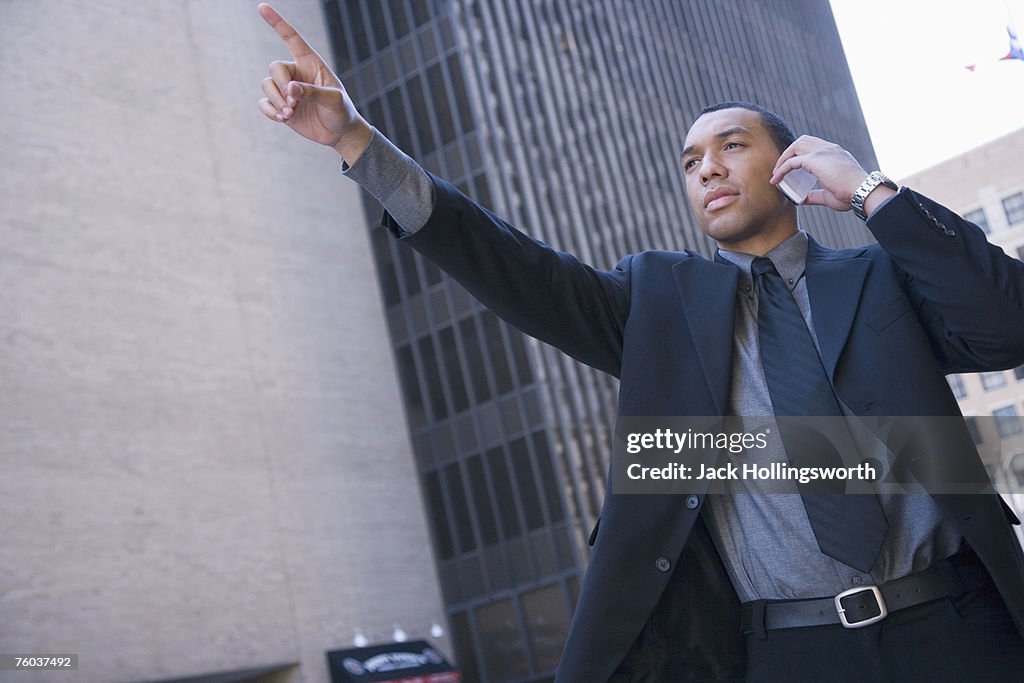 Businessman hailing cab in street