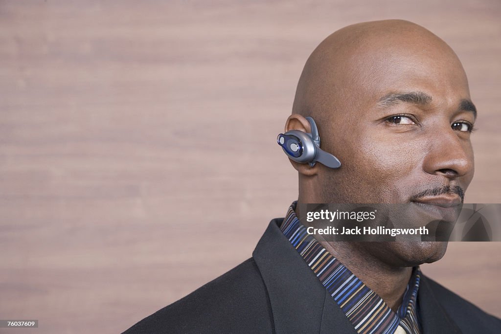 Mature businessman wearing hands free device, portrait, head and shoulders