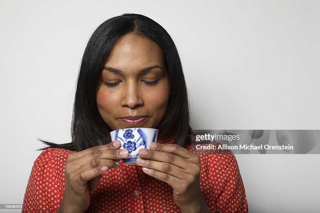Woman drinking tea, studio shot