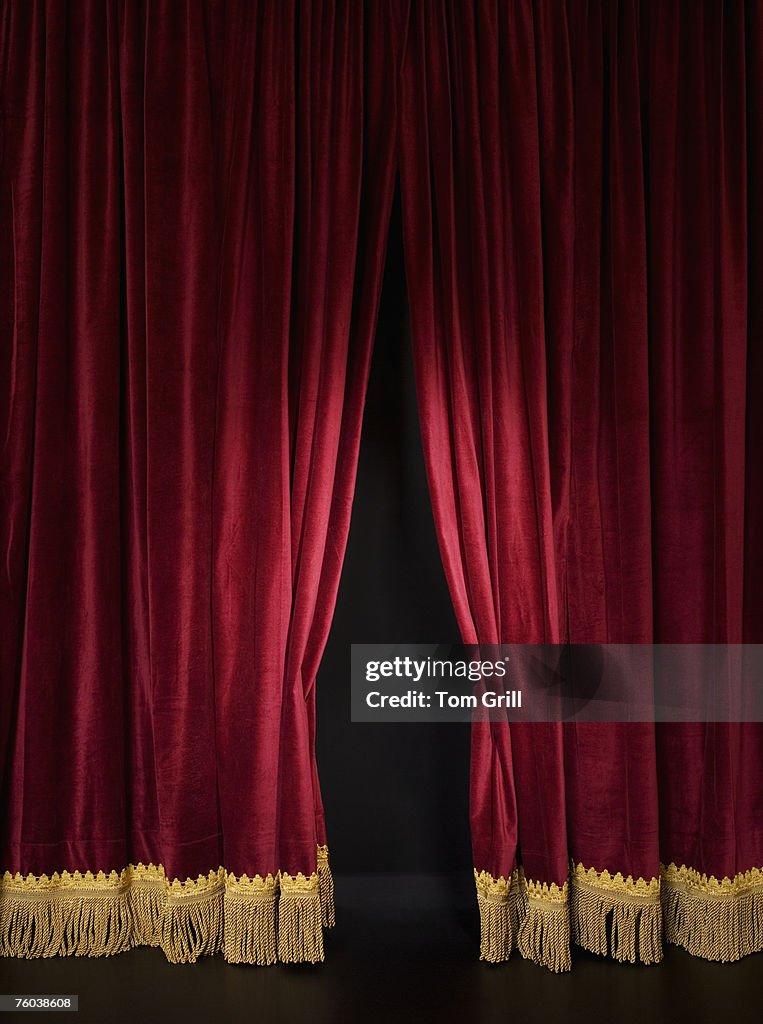 Spotlight on opening red stage curtain