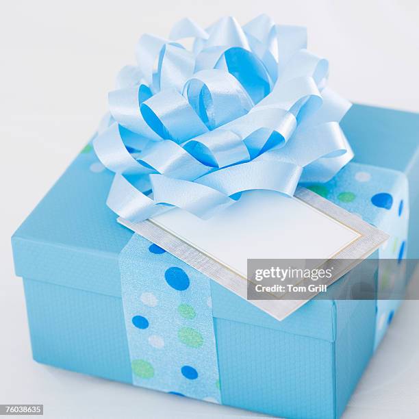 wrapped blue present with gift tag, close-up - gift box tag stockfoto's en -beelden