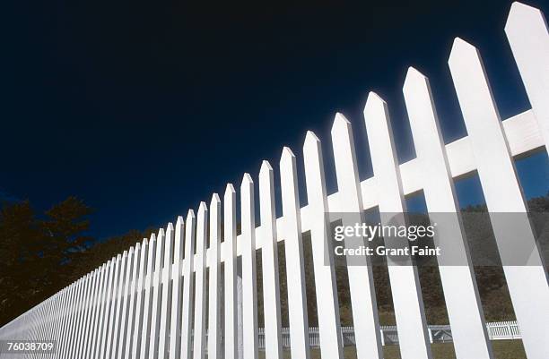 white picket fence at night, low angle view - tuinhek stockfoto's en -beelden