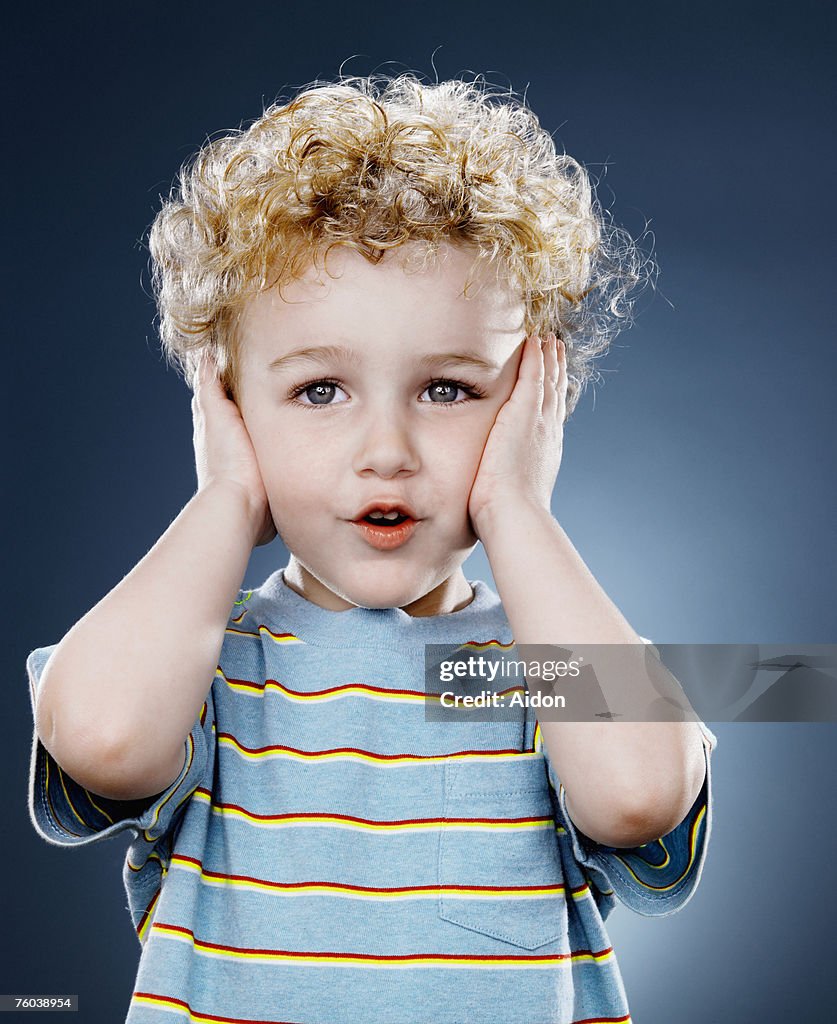 Boy (2-4) covering ears, close-up
