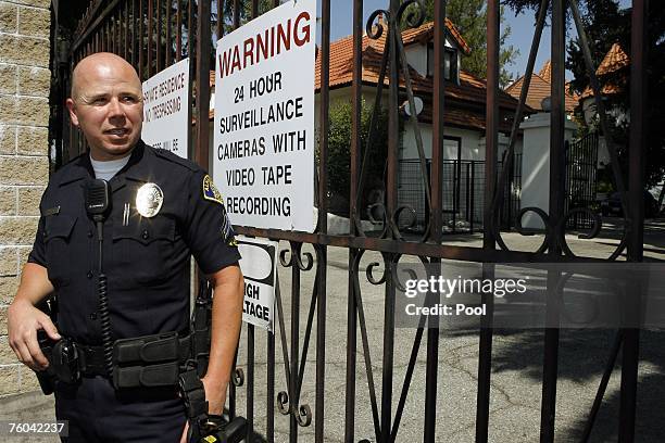 Alhambra Police Cpl. Sean Heckers stands outside the back gate of the mansion of music producer Phil Spector, as a panel of jurors visits the crime...