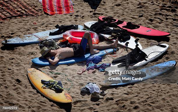 Surfer sleeps on the beach close to the Ripcurl Boardmasters at Fistral Beach on August 9, 2007 in Newquay, England. The annual festival at Newquay...